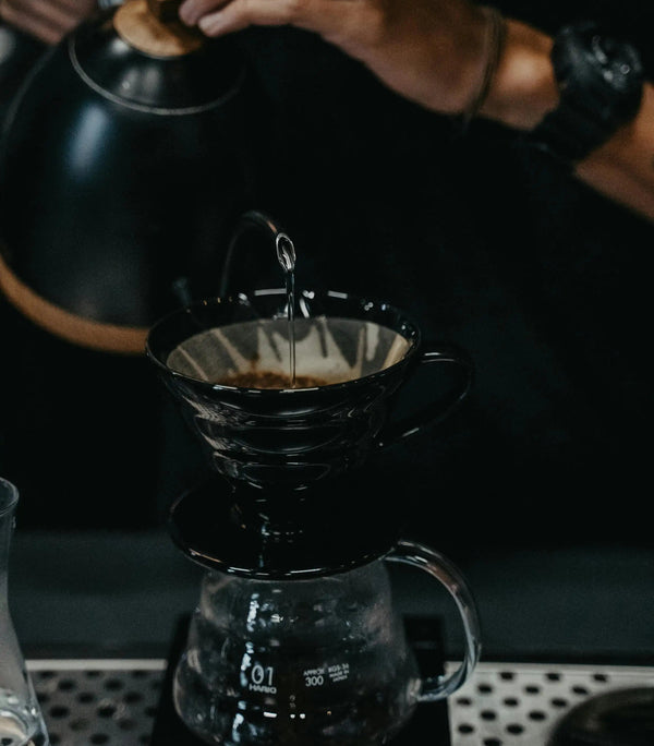 Barista che versa acqua nel caffè